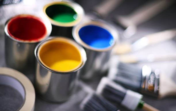 Paint cans and paintbrushes of different size  for home decorating purposes.